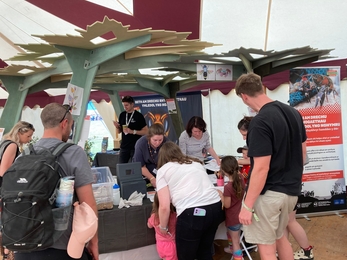 People engaging with the Ecosystem Invaders campaign stand at the Eisteddfod, participating in an eDNA activity