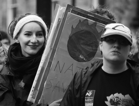 Black and white photo of two forum members standing with climate protest signs