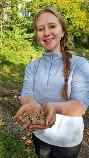 Young person holding wildflower seeds up to the camera