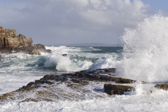 Waves crashing over rocky coastline