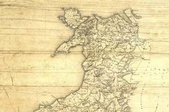 An old style map of Wales, with a sepia wood effect background and hand drawn look.