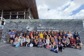 A group of young people posing outside the Senedd in Cardiff