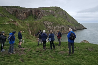 Walkers standing on a headland at Rhiwledyn Nature Reserve