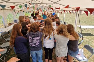 image shows a group of people in a marquee taking part in a big group activity