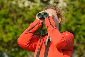 Young woman birdwatching at Rutland Water