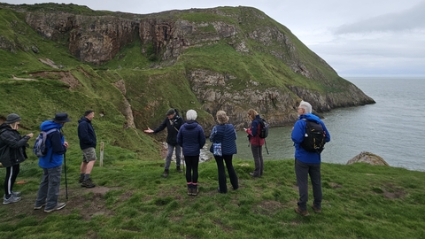 Walkers standing on a headland at Rhiwledyn Nature Reserve