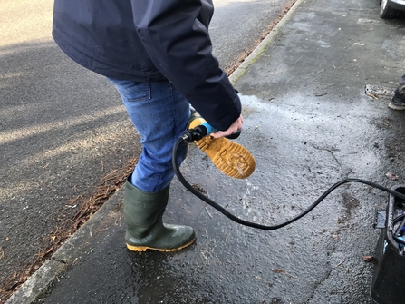 Project officer cleaning wellingtons