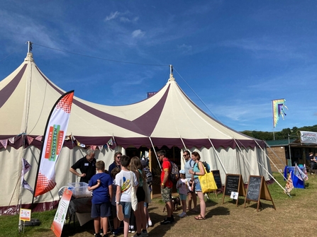 People engaging with the Ecosystem Invaders campaign stand at the Eisteddfod, participating in an eDNA activity
