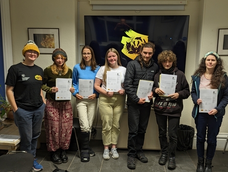 Seven young people standing with their award certificates