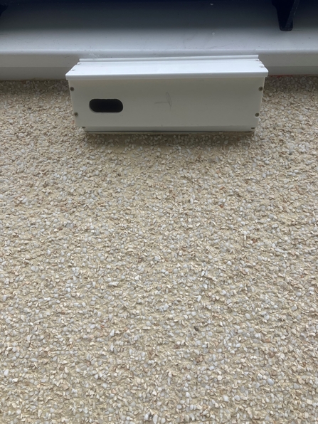 White swift box on a wall, under the eaves of a house