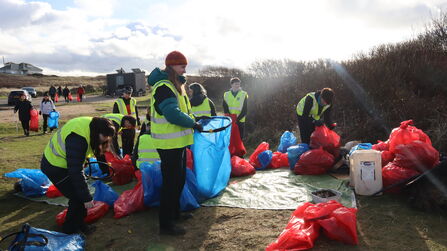 Event volunteers helping to sort out beach clean equipment
