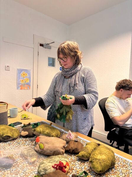 Alison with a fabric depiction of the rocky shore