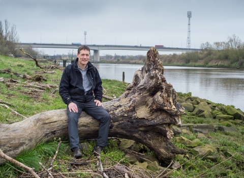 Jeremy sat on a log next to a river