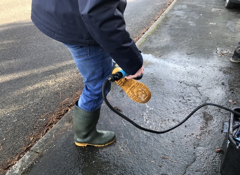 Project officer cleaning wellingtons