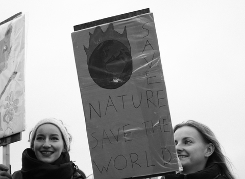 Two young people holding climate protest signs